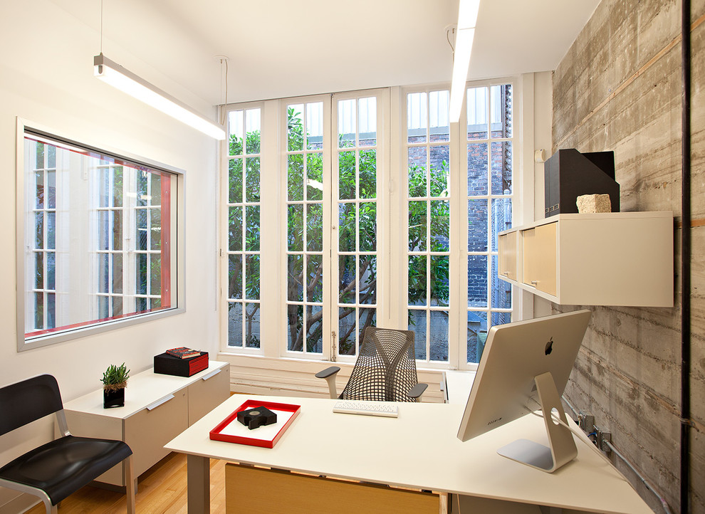 Exemple d'un petit bureau moderne avec un mur blanc, un bureau indépendant, un sol en bois brun et un sol marron.