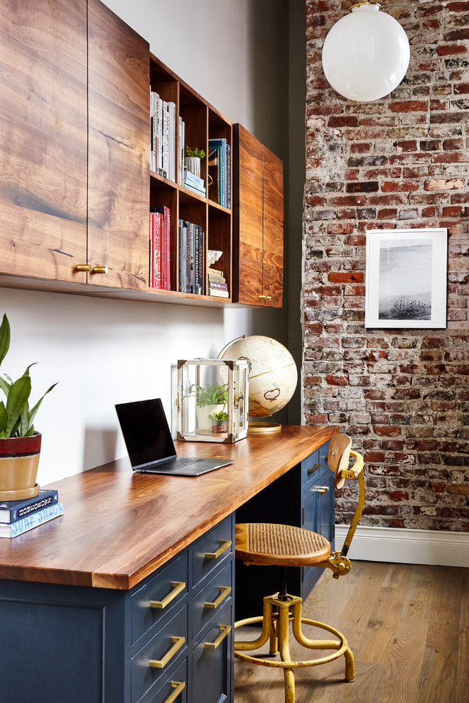 Foto di uno studio tradizionale con pareti bianche, pavimento in legno massello medio, scrivania incassata e pavimento marrone
