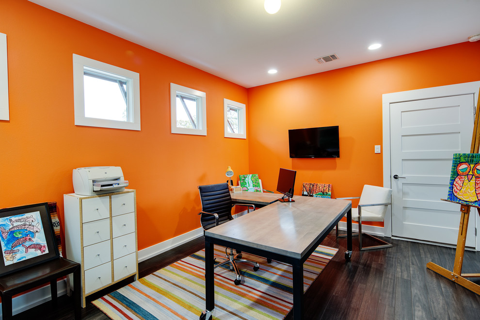 Cette photo montre un bureau moderne de taille moyenne avec un mur orange, parquet foncé, aucune cheminée et un bureau indépendant.