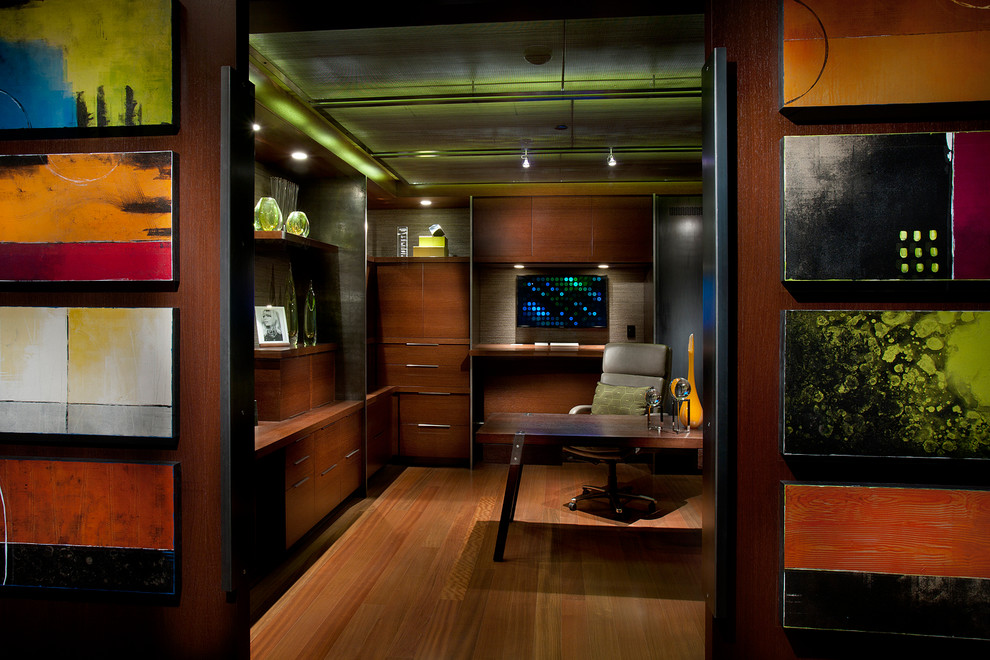 Immagine di un grande studio design con pavimento in legno massello medio, scrivania autoportante, pareti marroni e pavimento marrone