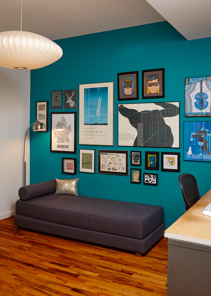 Idee per uno studio minimalista di medie dimensioni con pareti blu, pavimento in legno massello medio e scrivania autoportante