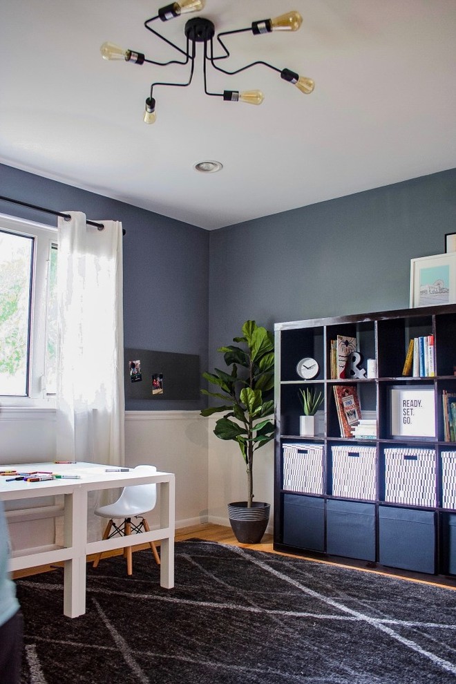 Ejemplo de sala de manualidades moderna de tamaño medio sin chimenea con paredes azules, suelo de madera en tonos medios, escritorio independiente y suelo marrón