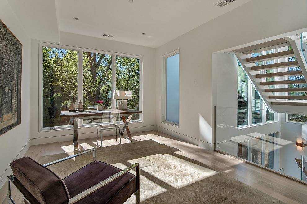 Large contemporary study in DC Metro with white walls, light hardwood flooring and beige floors.