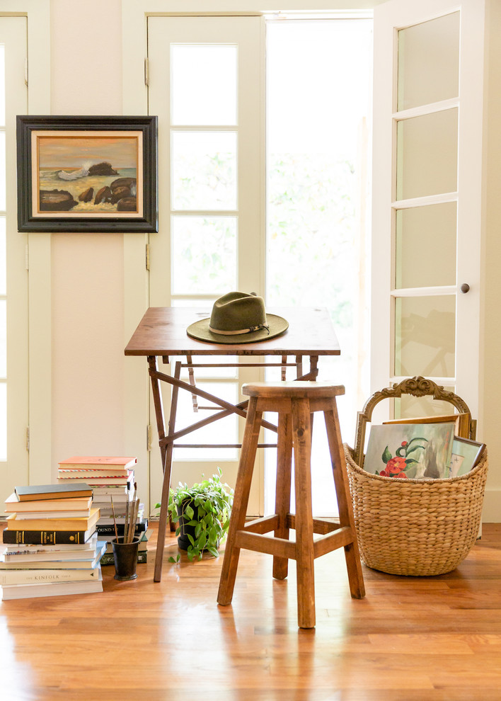 Inspiration för små klassiska hemmabibliotek, med mellanmörkt trägolv, ett fristående skrivbord, brunt golv och rosa väggar
