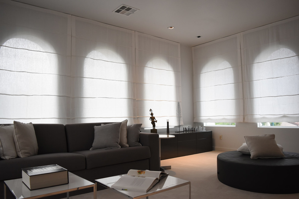 Diseño de estudio minimalista grande con paredes blancas, moqueta y escritorio independiente