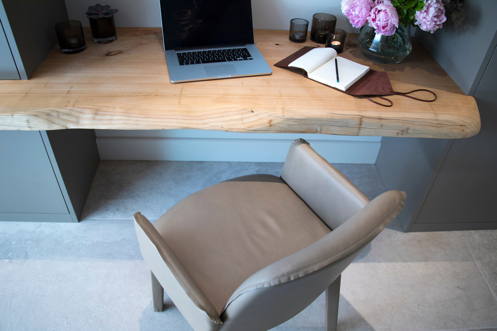 Modelo de despacho actual de tamaño medio sin chimenea con paredes blancas, suelo de baldosas de cerámica, escritorio empotrado y suelo blanco