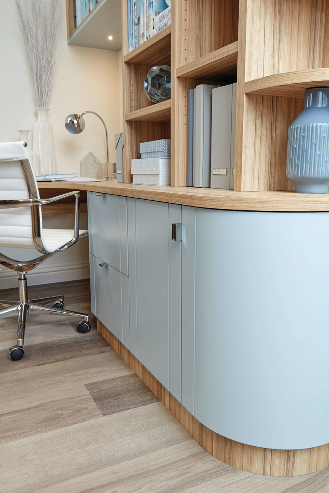Kleines Klassisches Arbeitszimmer mit Arbeitsplatz, weißer Wandfarbe, Laminat, Einbau-Schreibtisch und braunem Boden in Sonstige