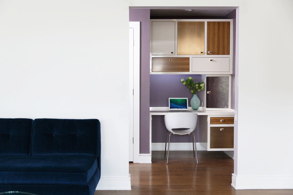 Idéer för att renovera ett mellanstort funkis hemmastudio, med lila väggar, mellanmörkt trägolv och ett inbyggt skrivbord