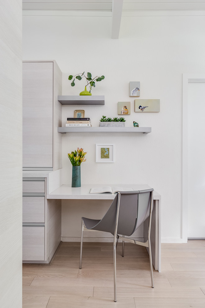 Idee per un piccolo studio minimalista con pareti bianche, parquet chiaro, scrivania incassata, pavimento beige e soffitto in perlinato