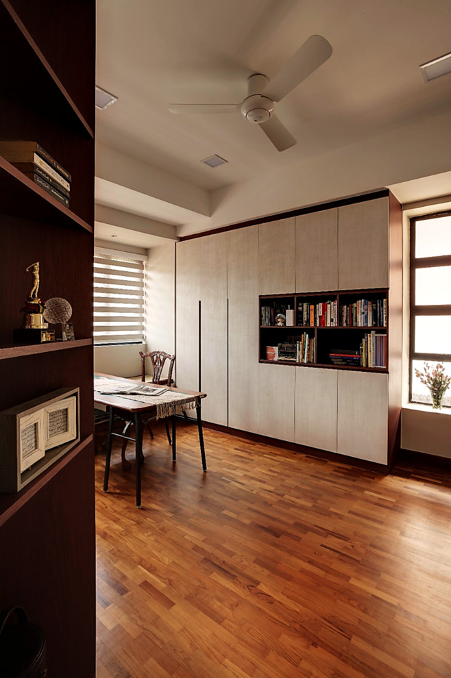 Imagen de despacho de estilo zen de tamaño medio con suelo de madera en tonos medios y escritorio independiente