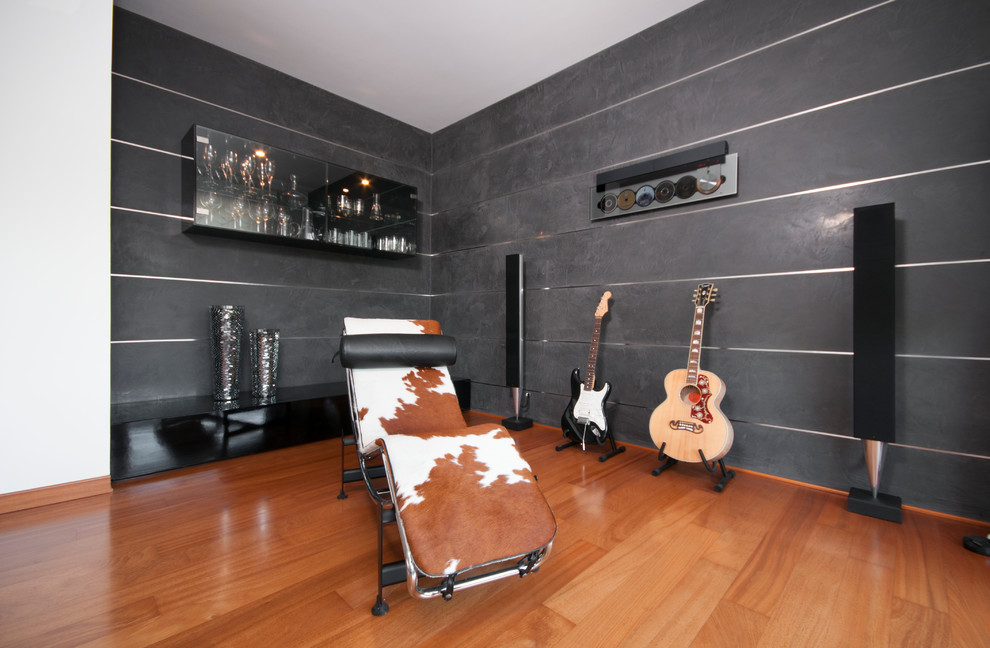Ejemplo de despacho moderno con suelo de madera en tonos medios y paredes grises