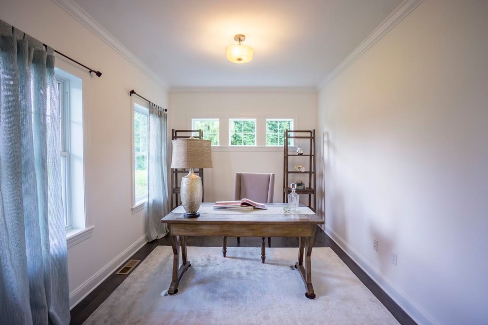 Diseño de despacho de estilo americano de tamaño medio sin chimenea con paredes blancas, suelo de madera oscura, escritorio independiente y suelo marrón