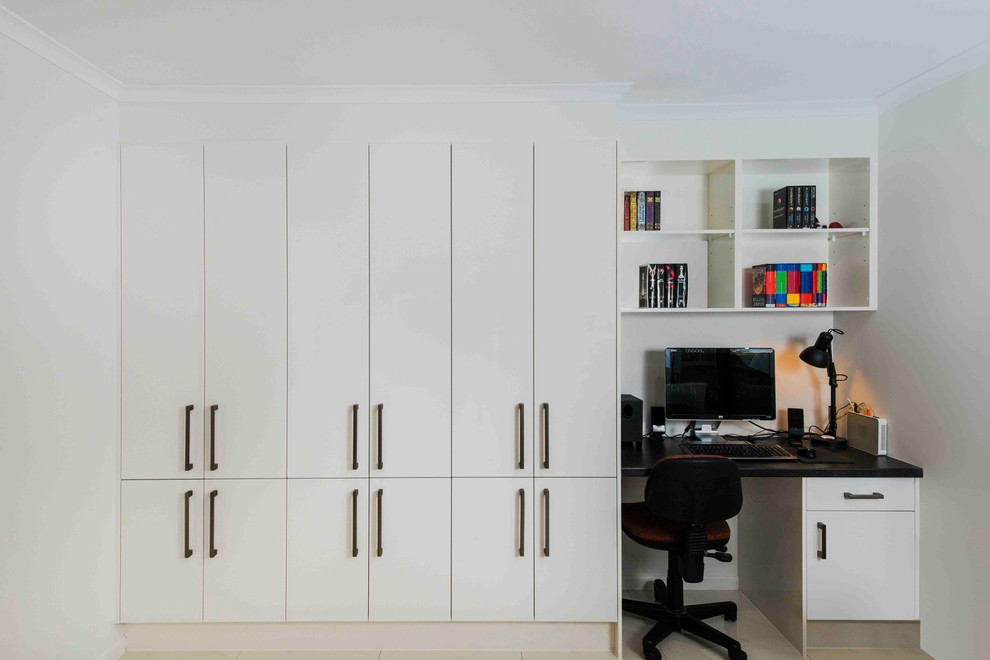Idéer för ett modernt hemmabibliotek, med vita väggar, klinkergolv i keramik och ett inbyggt skrivbord