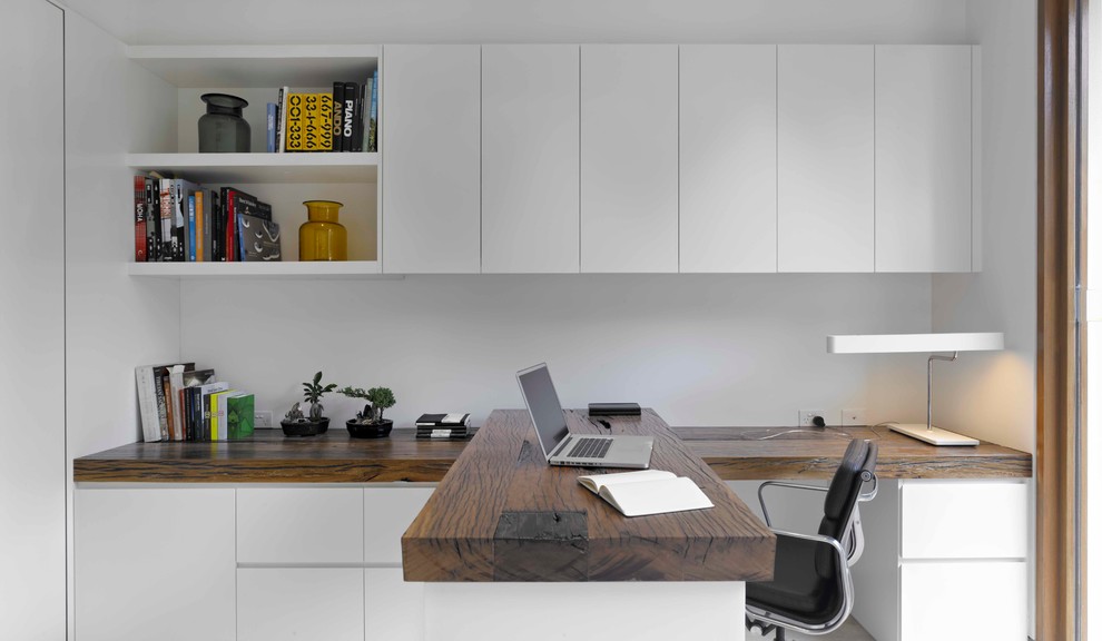 Пример оригинального дизайна: кабинет в современном стиле с белыми стенами и встроенным рабочим столом