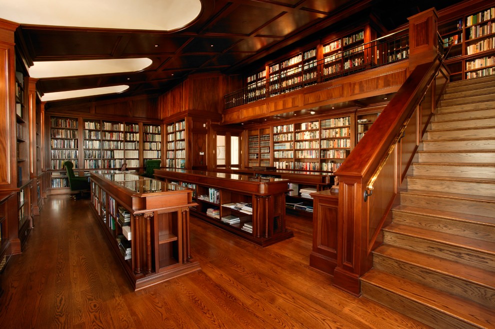 Diseño de despacho clásico extra grande con biblioteca, suelo de madera en tonos medios y escritorio empotrado
