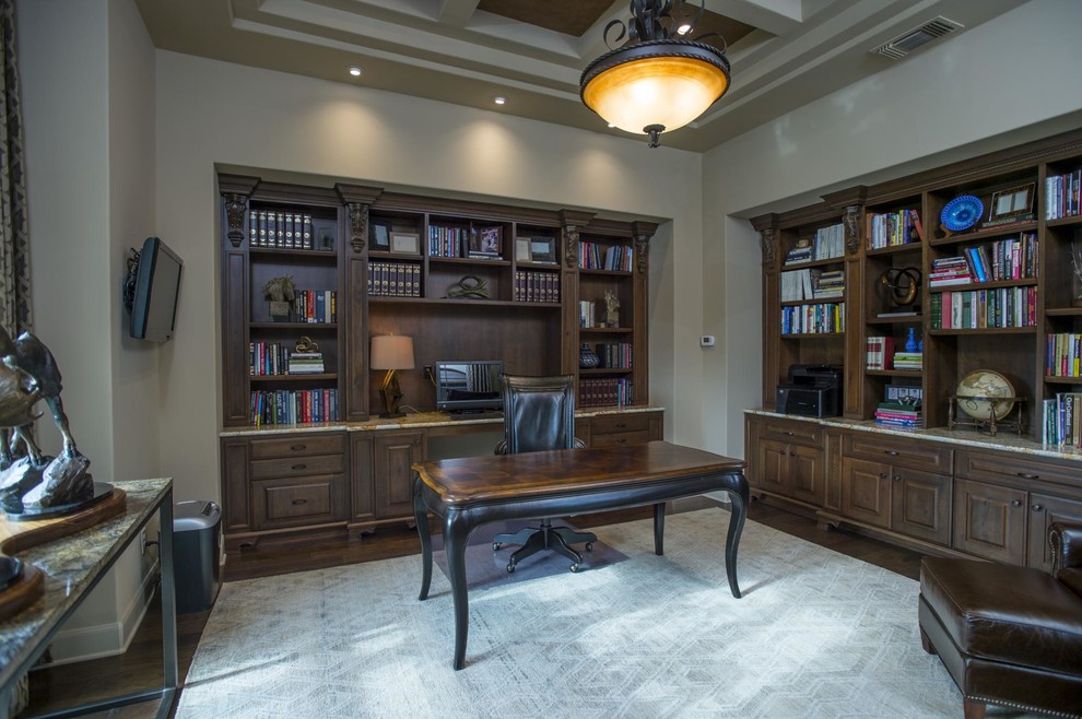 Idéer för ett stort modernt hemmabibliotek, med mellanmörkt trägolv och ett fristående skrivbord
