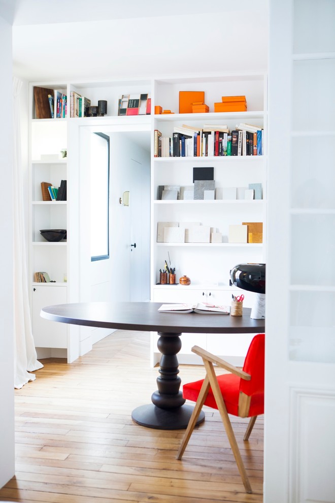 Immagine di un ufficio minimal di medie dimensioni con scrivania autoportante, pareti bianche e pavimento in legno massello medio