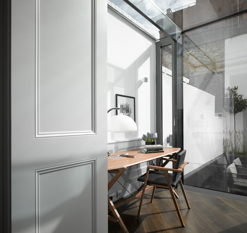 На фото: кабинет в современном стиле с белыми стенами, темным паркетным полом и отдельно стоящим рабочим столом