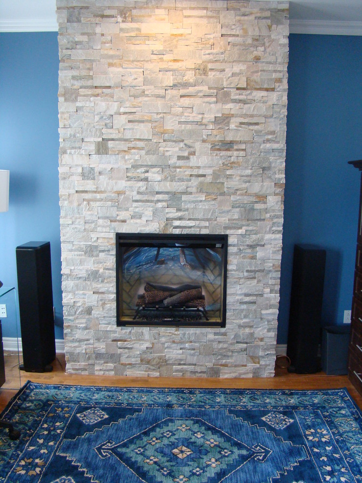 モントリオールにあるお手頃価格の中くらいなコンテンポラリースタイルのおしゃれなホームオフィス・書斎 (青い壁、無垢フローリング、標準型暖炉、石材の暖炉まわり、自立型机、青い床) の写真