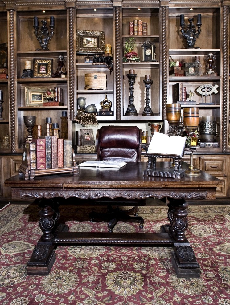 Foto på ett mycket stort vintage hemmabibliotek, med beige väggar, mörkt trägolv, ett fristående skrivbord och brunt golv