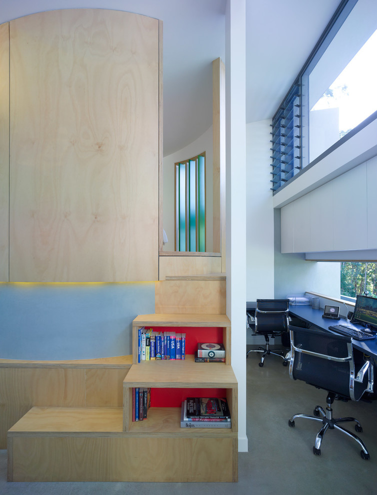 Immagine di un piccolo ufficio moderno con pavimento in cemento e scrivania incassata