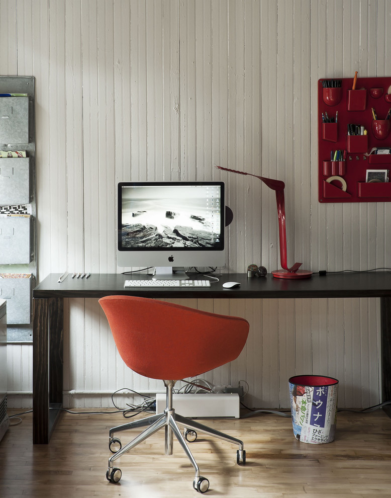 This is an example of a medium sized eclectic study in Auckland with white walls, light hardwood flooring and a freestanding desk.