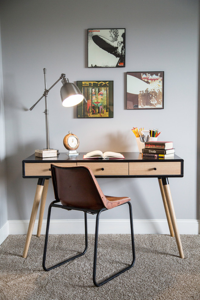 Foto di uno studio minimal con pareti grigie, moquette, scrivania autoportante e pavimento grigio