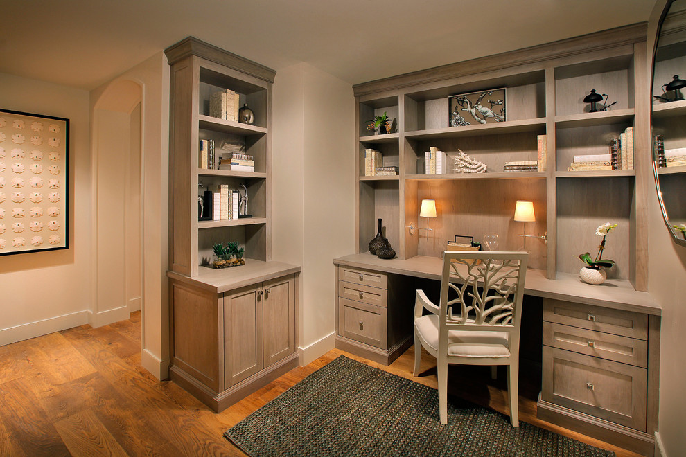 Photo of a coastal home office in Miami with beige walls, medium hardwood flooring and a built-in desk.