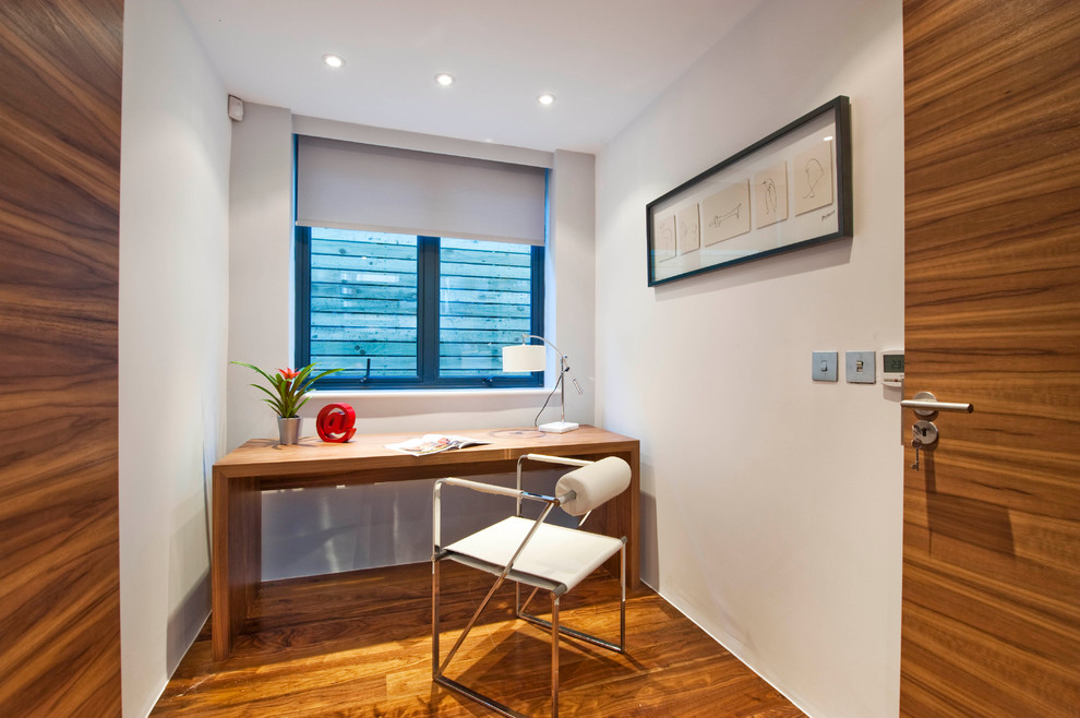 Example of a minimalist home office design in London with white walls
