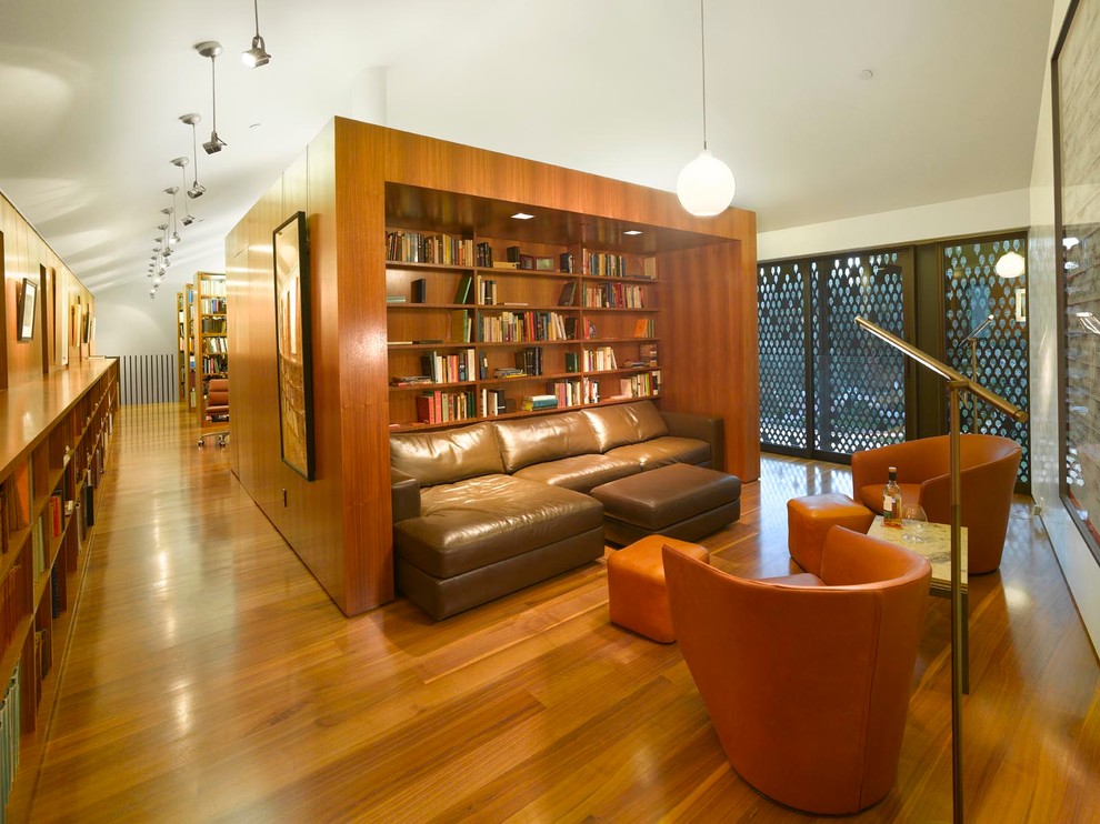 Foto di un ampio studio minimalista con libreria, pareti bianche, pavimento in legno massello medio e scrivania autoportante