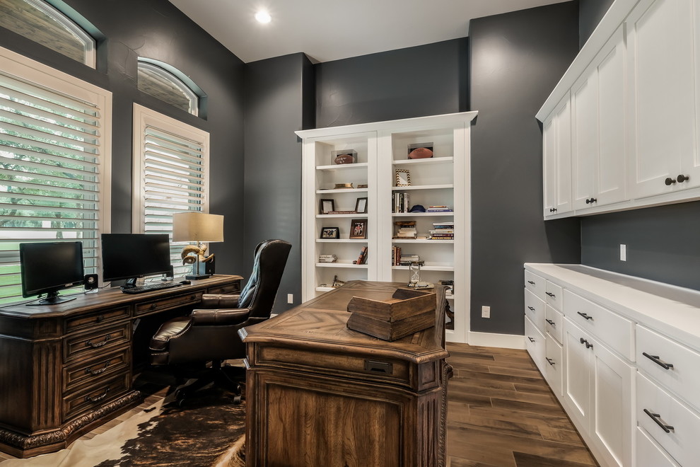 Aménagement d'un bureau classique avec un mur gris, un sol en bois brun, aucune cheminée, un bureau indépendant et un sol marron.
