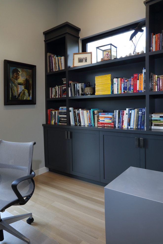 Design ideas for a modern study in Minneapolis with white walls, light hardwood flooring and a freestanding desk.