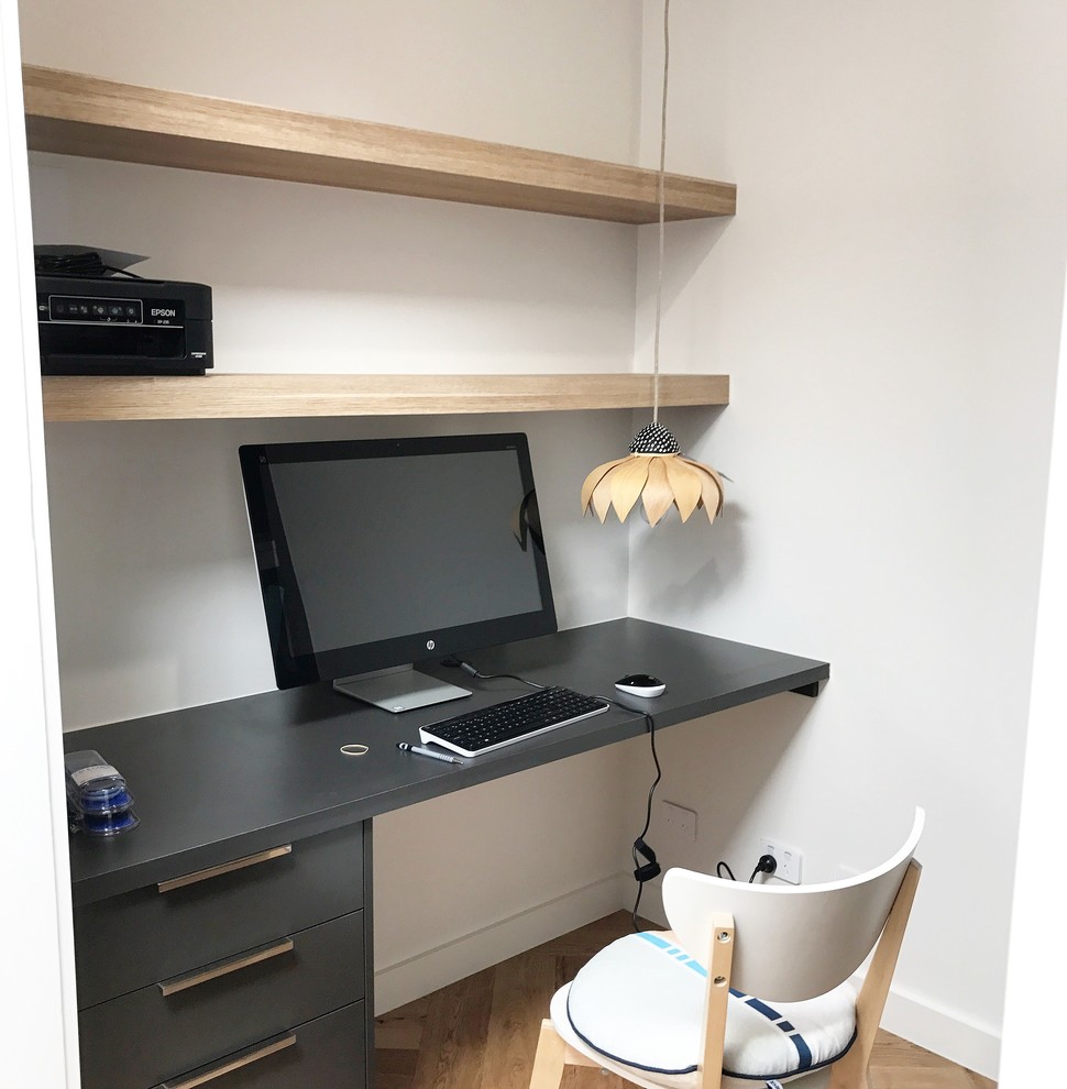 Idee per un piccolo ufficio moderno con pareti bianche, parquet chiaro e scrivania incassata