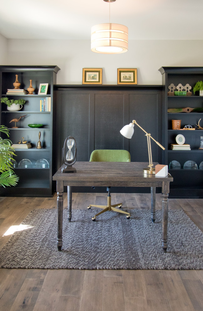 Imagen de despacho campestre con paredes blancas, suelo de madera en tonos medios, escritorio independiente y suelo marrón