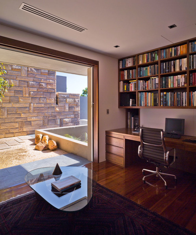 Inspiration for a large modern study in Sydney with white walls, dark hardwood flooring and a built-in desk.