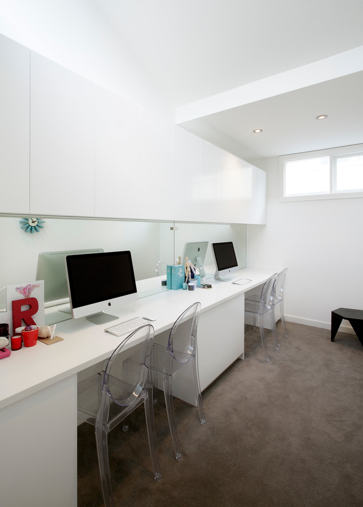 Exempel på ett modernt arbetsrum, med vita väggar, heltäckningsmatta och ett inbyggt skrivbord