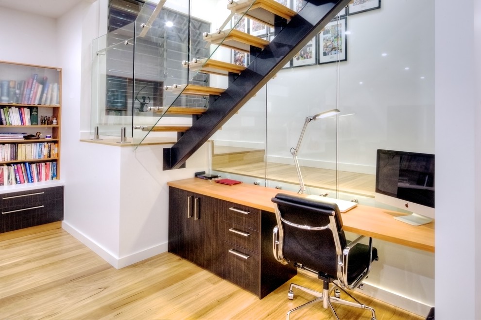 Kleines Modernes Arbeitszimmer mit Arbeitsplatz, weißer Wandfarbe, hellem Holzboden und freistehendem Schreibtisch in Sydney