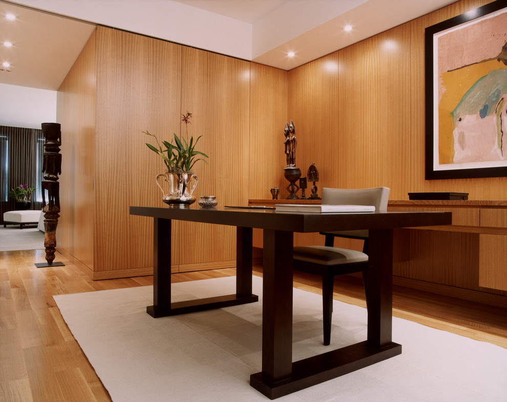 Aménagement d'un bureau moderne avec un sol en bois brun et un bureau indépendant.