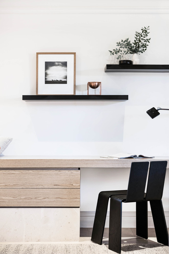 Modelo de despacho minimalista de tamaño medio con paredes blancas, suelo de piedra caliza y escritorio empotrado
