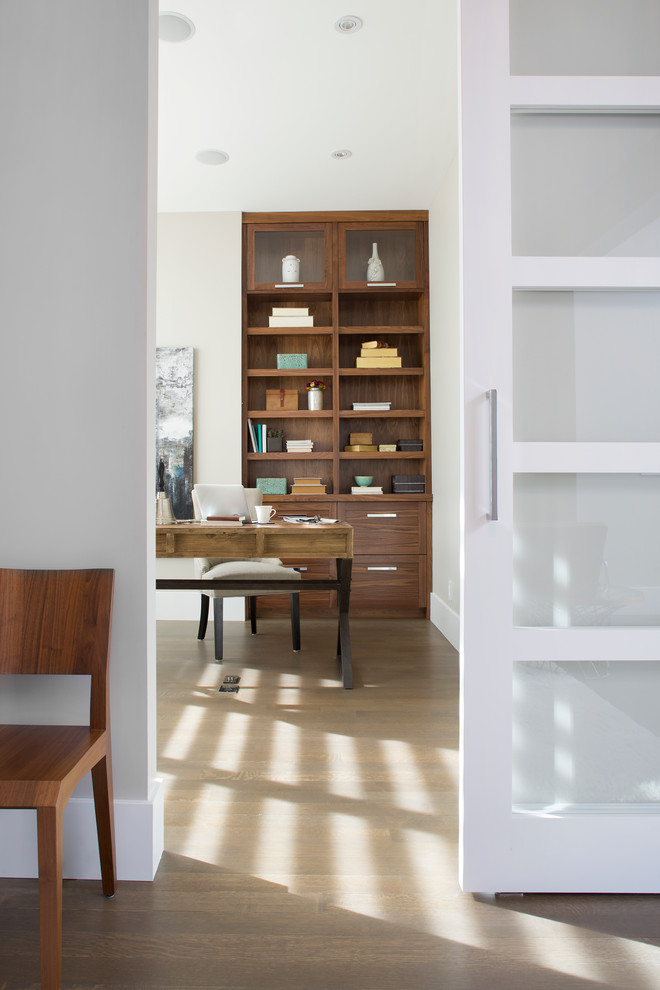 На фото: кабинет среднего размера в стиле неоклассика (современная классика) с серыми стенами, полом из винила и отдельно стоящим рабочим столом с
