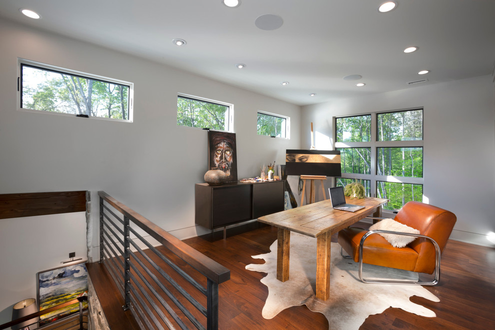Diseño de estudio contemporáneo de tamaño medio con paredes blancas, suelo de madera en tonos medios, escritorio independiente y suelo marrón