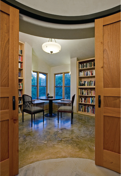 Ejemplo de despacho rústico de tamaño medio con biblioteca, suelo de cemento y suelo gris