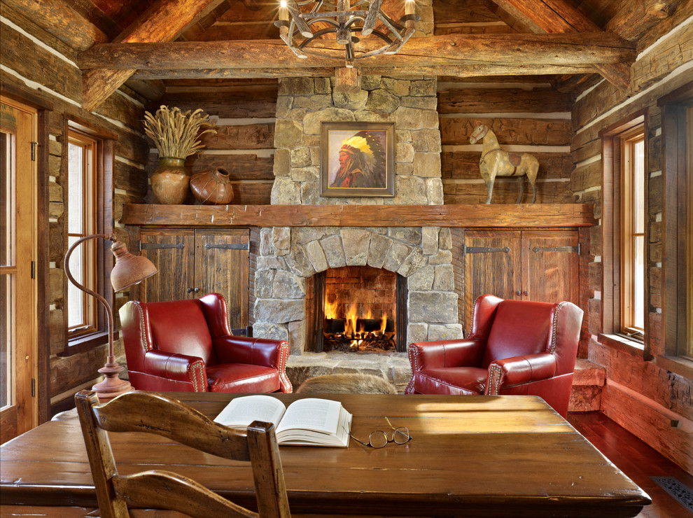 Photo of a medium sized rustic home office in Other with medium hardwood flooring, a standard fireplace, a stone fireplace surround and a freestanding desk.