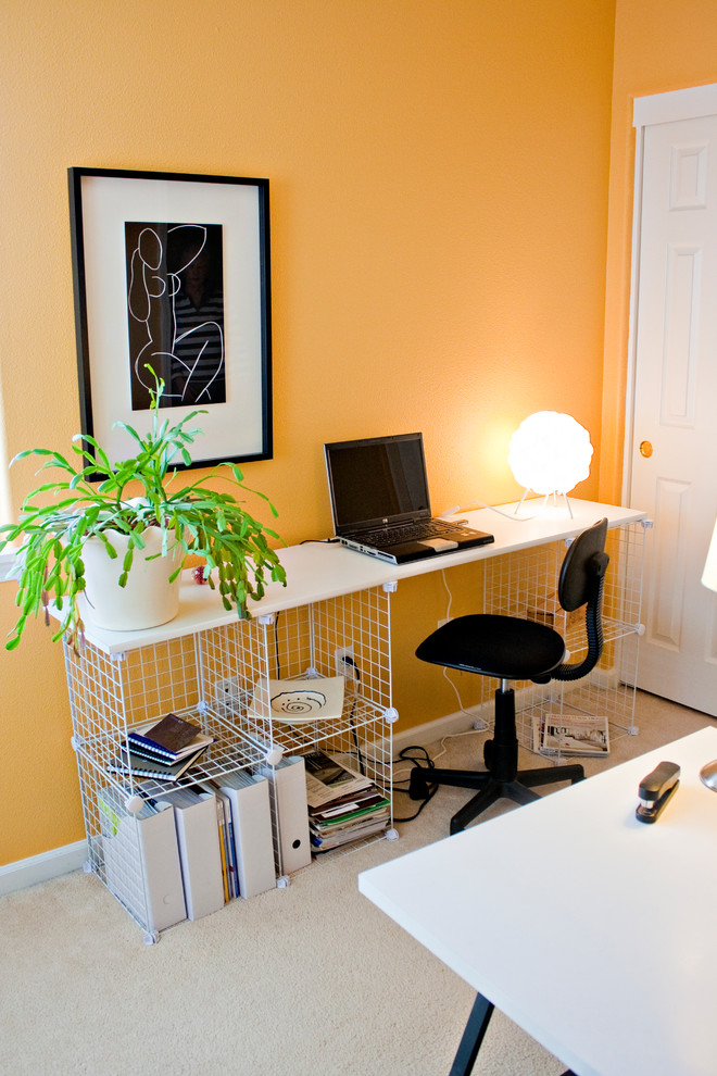 Diseño de despacho actual de tamaño medio sin chimenea con paredes amarillas, moqueta y escritorio independiente