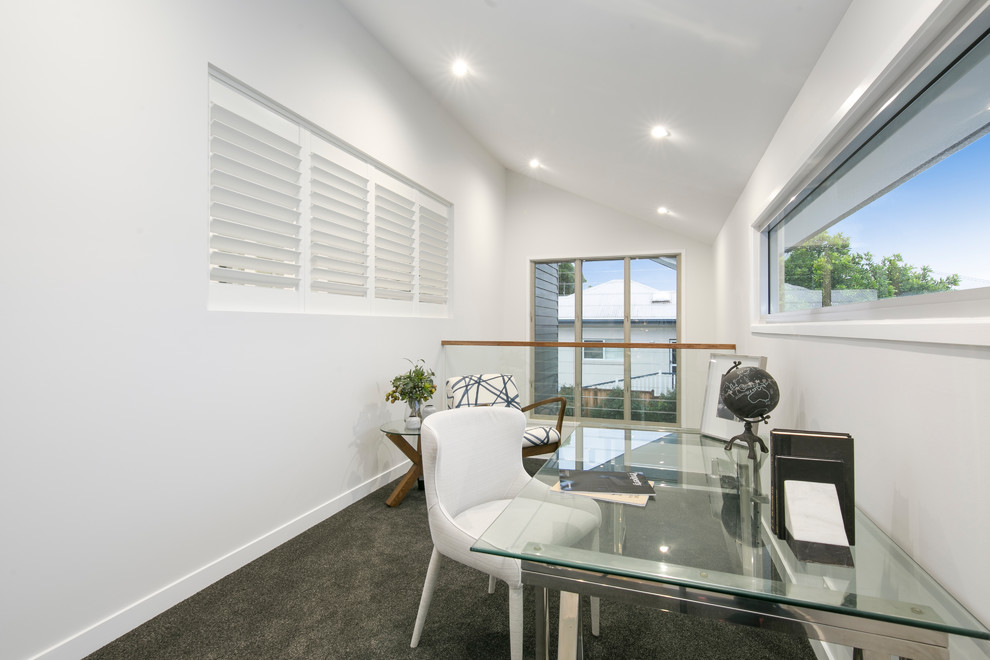 Large contemporary study in Brisbane with white walls, carpet, no fireplace, a freestanding desk and black floors.