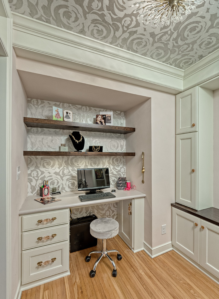 Ejemplo de despacho contemporáneo pequeño sin chimenea con paredes rosas, suelo de madera clara, escritorio empotrado y suelo marrón