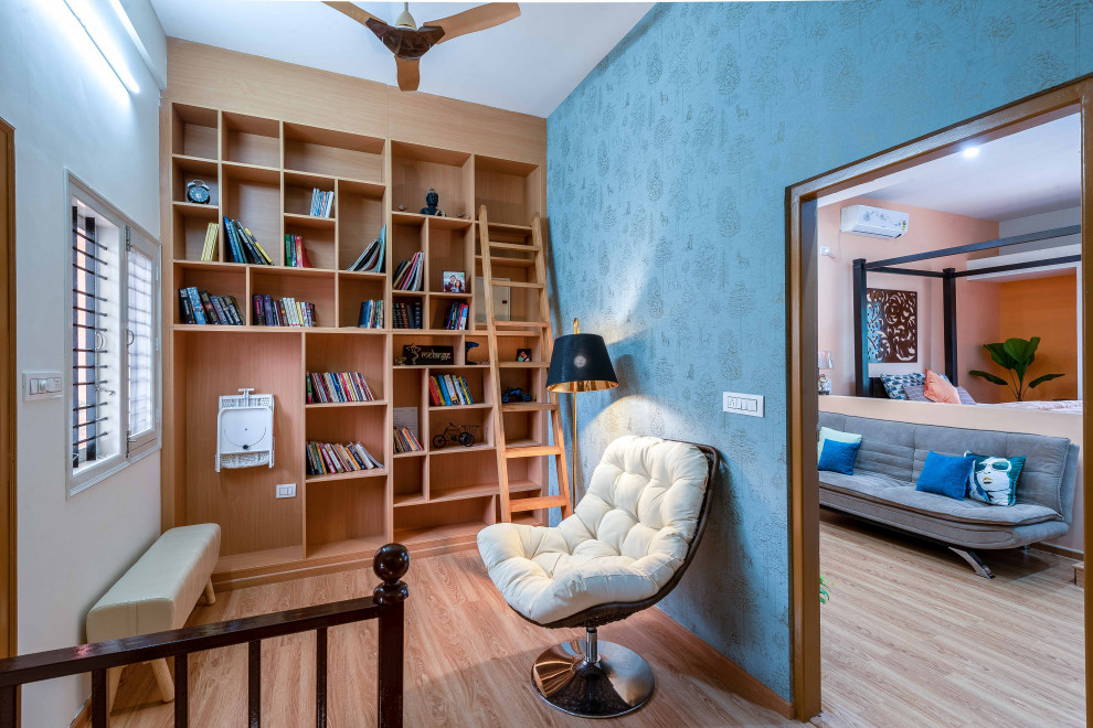 Inspiration för mellanstora moderna arbetsrum, med ett bibliotek, blå väggar, ljust trägolv och beiget golv