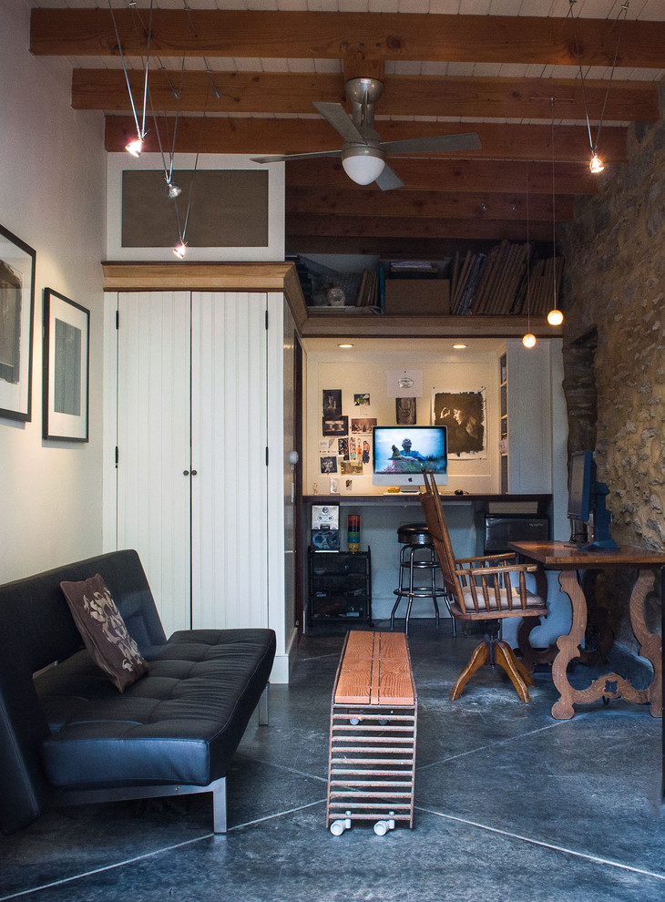Kleines Eklektisches Arbeitszimmer ohne Kamin mit Studio, weißer Wandfarbe, Betonboden und Einbau-Schreibtisch in Philadelphia