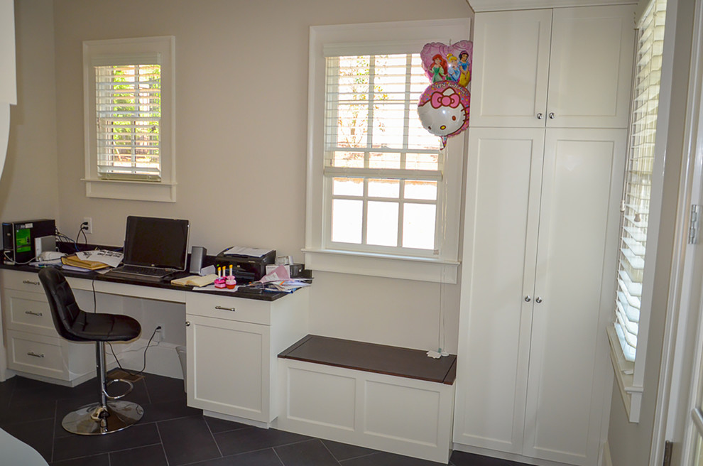 Photo of a large classic home office in Atlanta with white walls, slate flooring, a built-in desk and black floors.