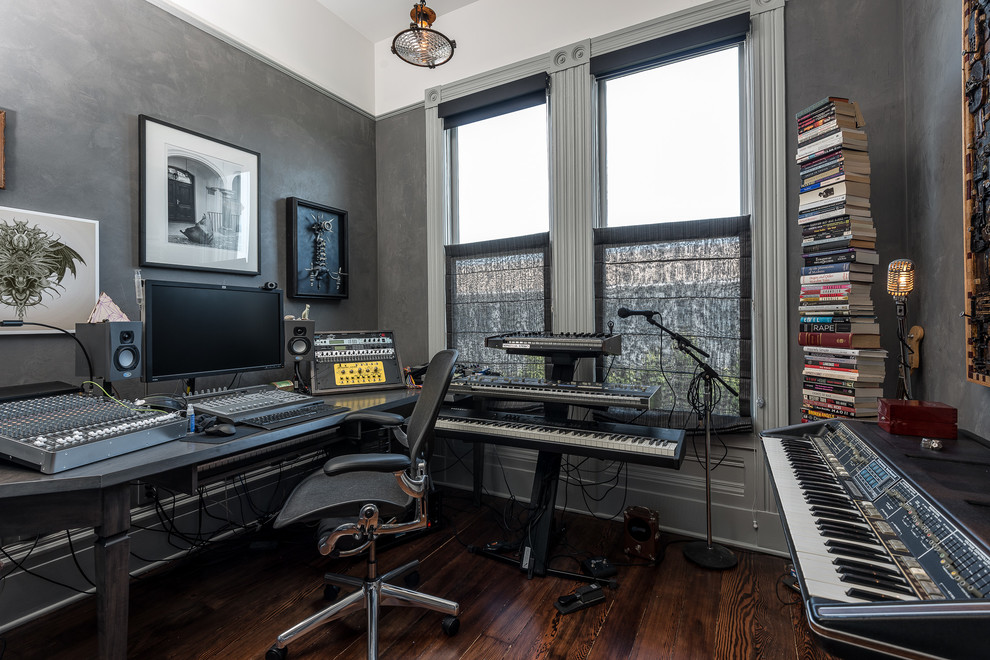 Bild på ett funkis hemmastudio, med grå väggar, brunt golv, mörkt trägolv och ett fristående skrivbord